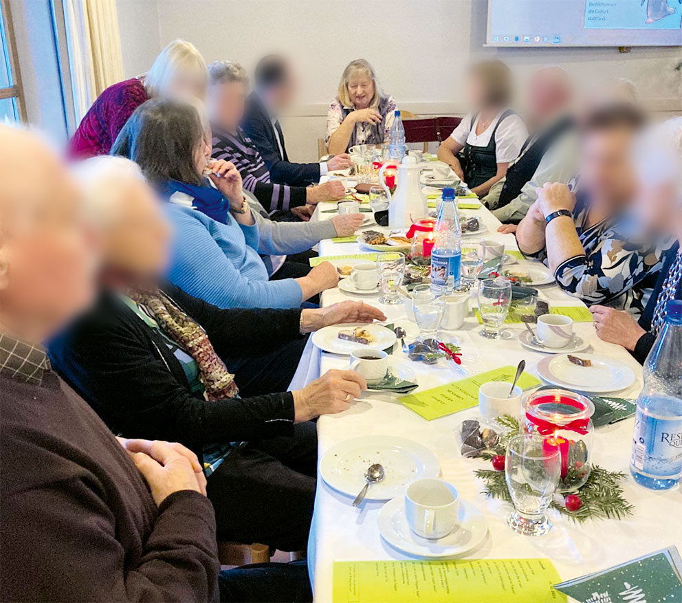 Senioren an gedecktem Tisch sitzend.
